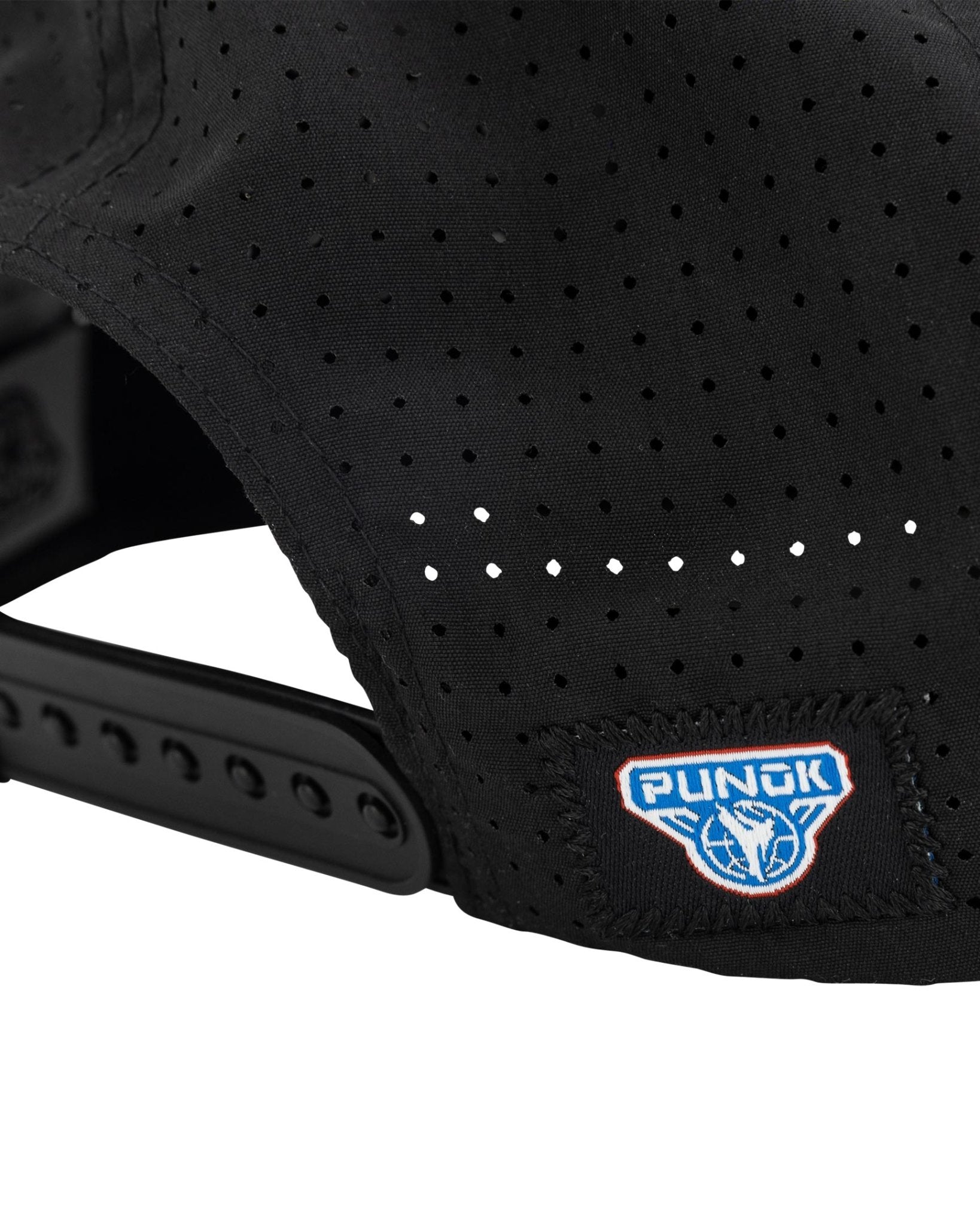 Black performance fighter hat close-up: perforated panels and small PUNOK side logo.