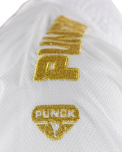 White gi with gold embroidered logo patch detail, close-up