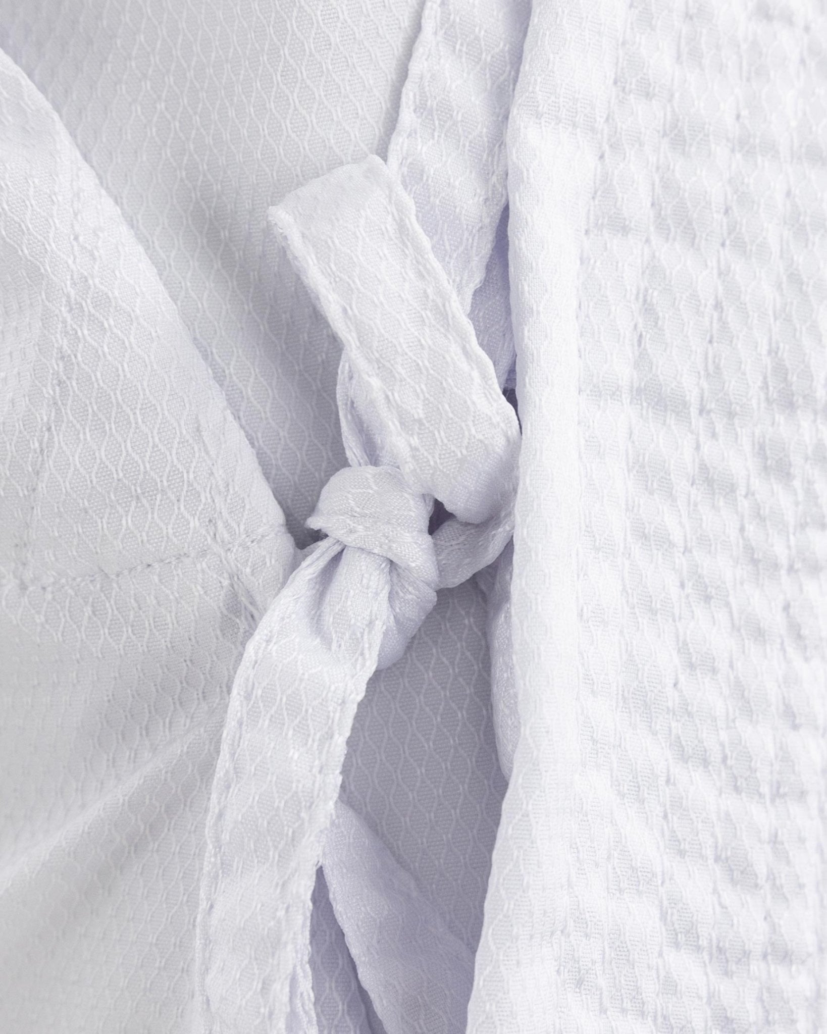 White karate gi with tied wrap knot at front