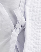 White karate gi with tied wrap knot at front