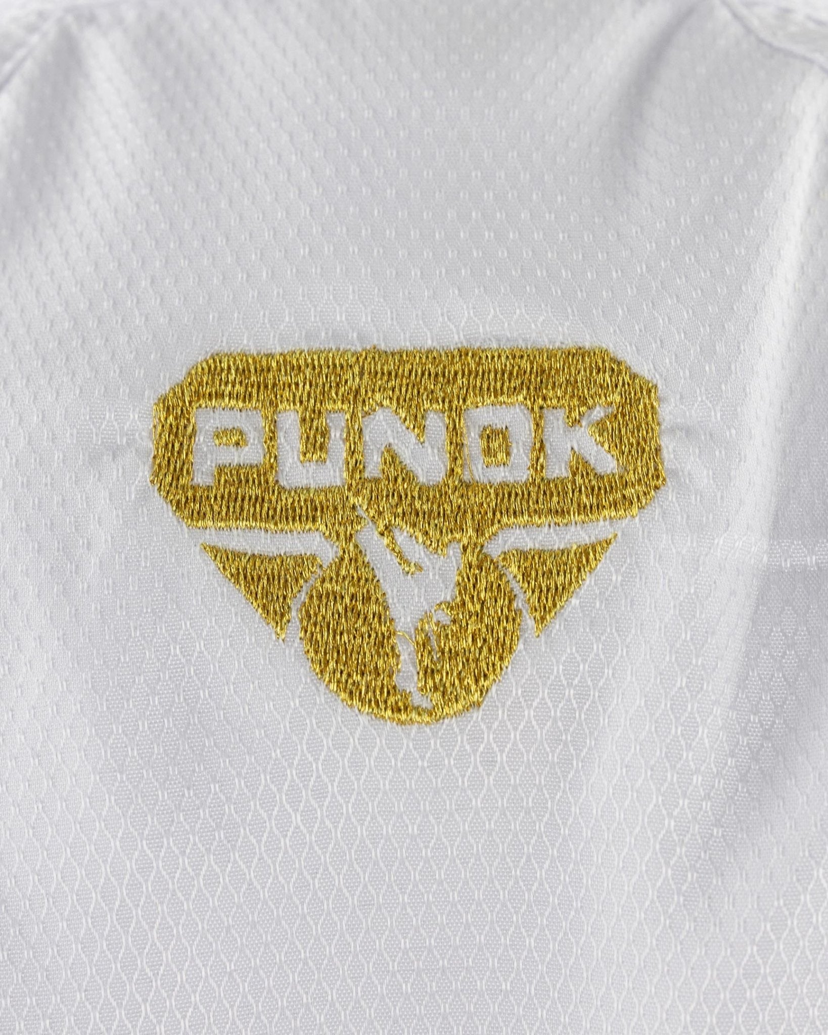 White karate gi top with gold Punok Takyon crest patch on chest