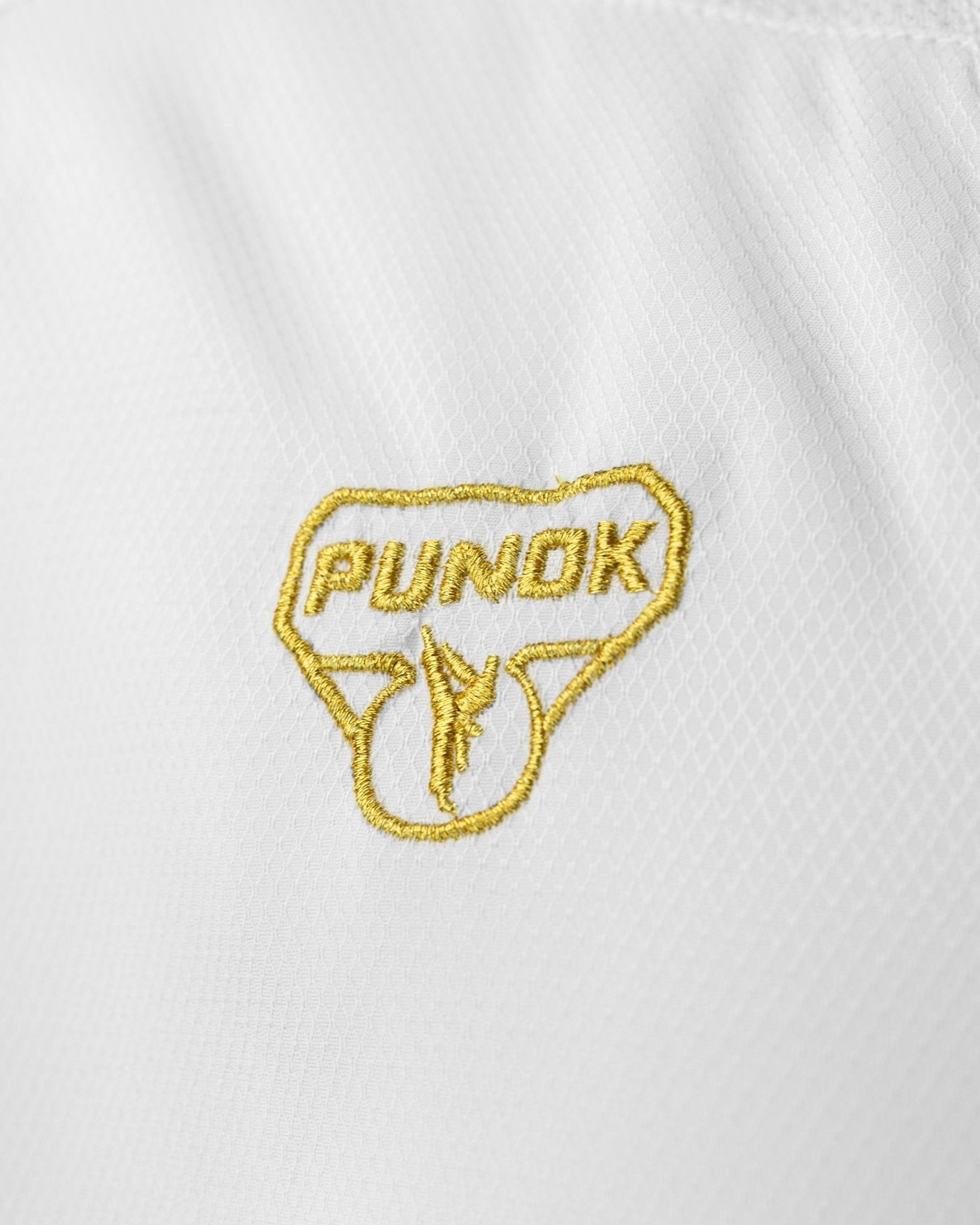 Close-up of Punok logo patch on white karate uniform fabric
