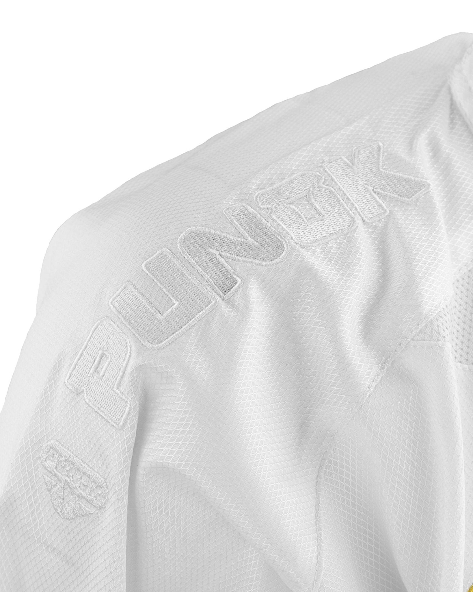 Close-up of embroidered lettering on white karate uniform jacket sleeve