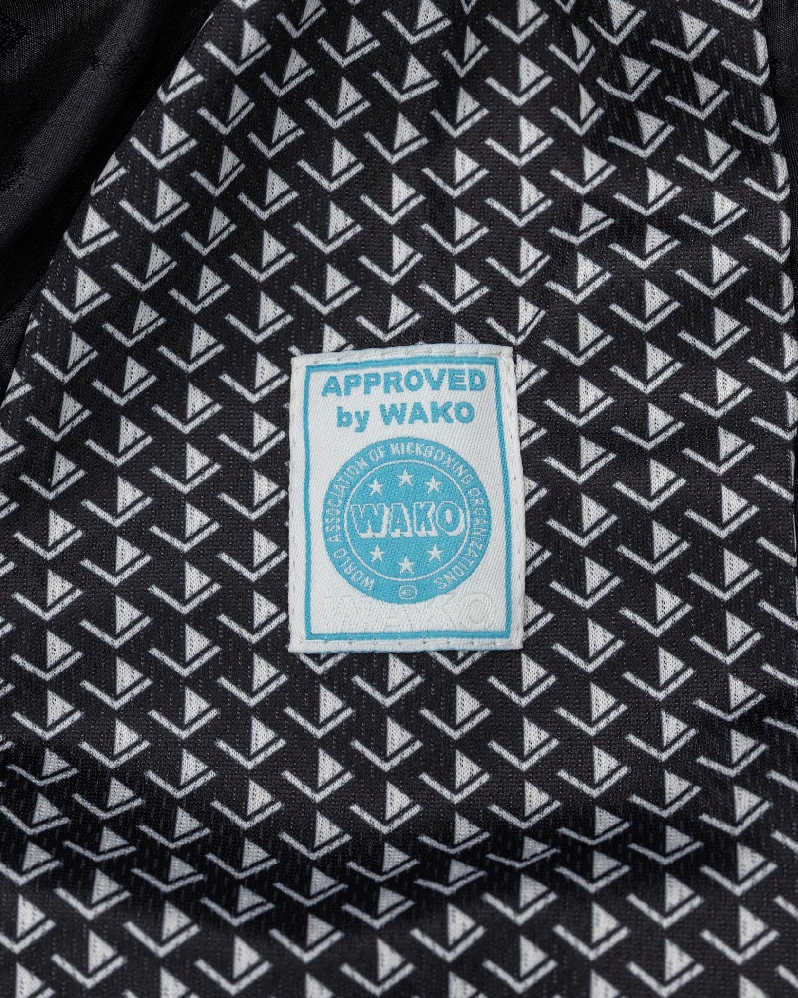 Tenacity pants fabric in dark with white geometric pattern and WAKO approval patch