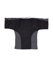 Black martial arts top with white trim around neckline and textured side panels