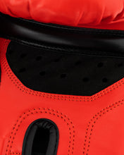 Close-up of red kickboxing glove interior, black ventilation panel and stitched edge