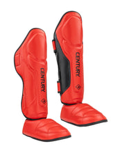 Pair of red shin instep guards with black straps and CENTURY logo on front.