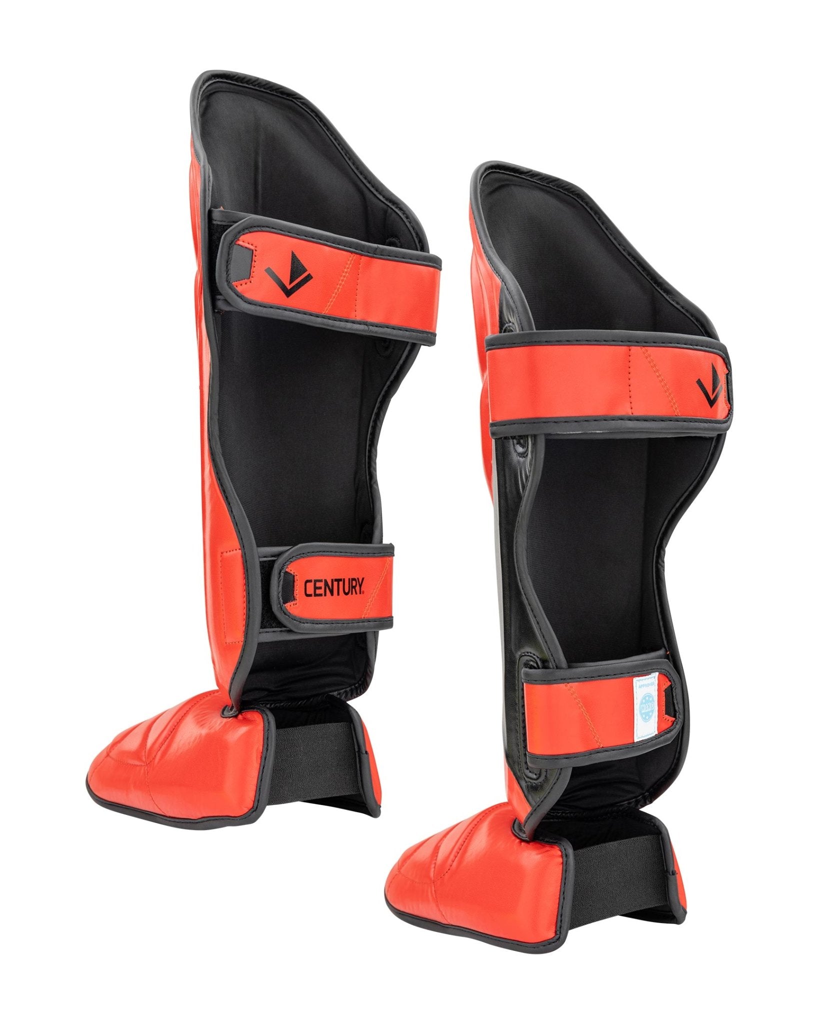 Black and orange shin instep guards with wide strap and CENTURY label on front.